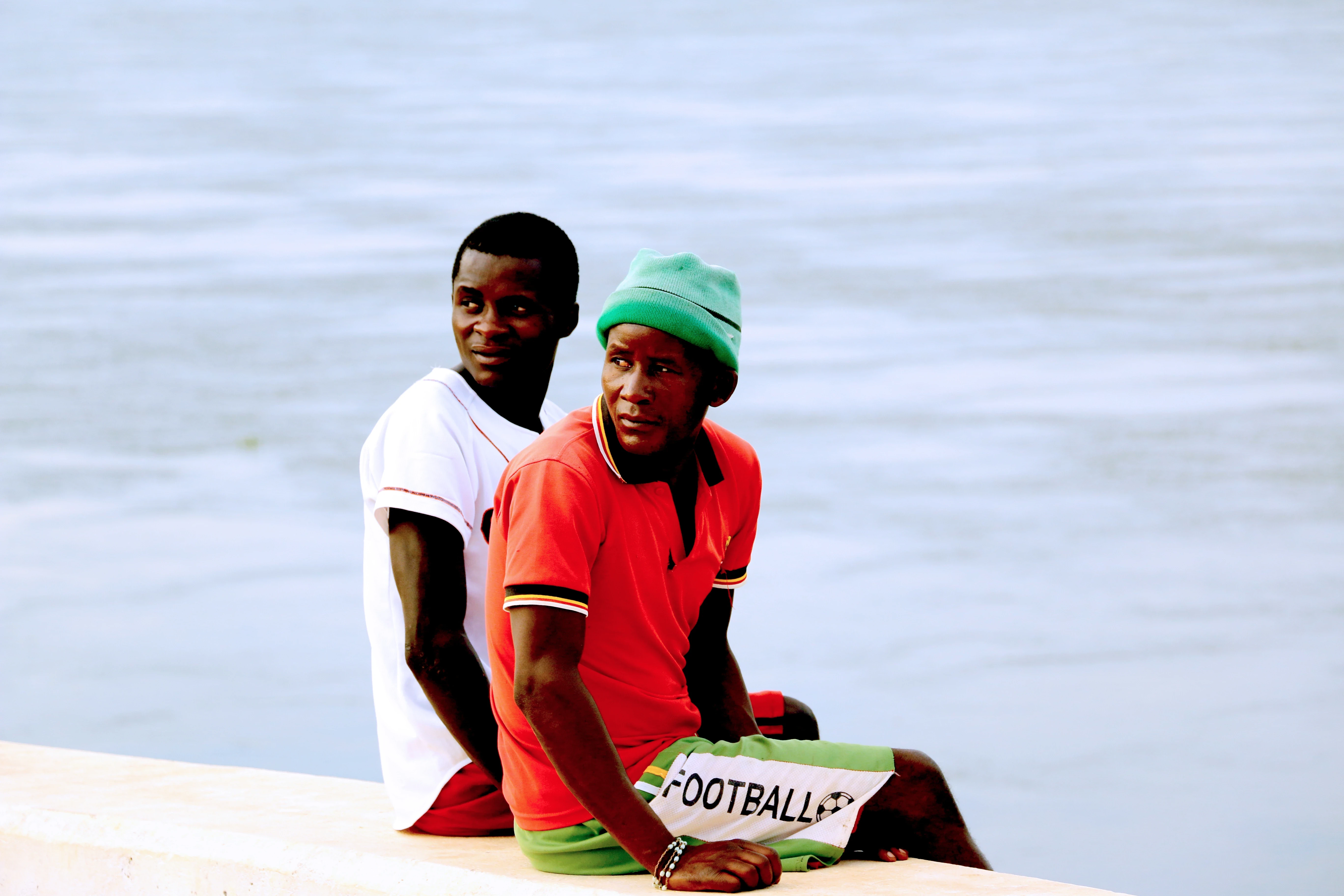 Two young men sitting by the waterfront