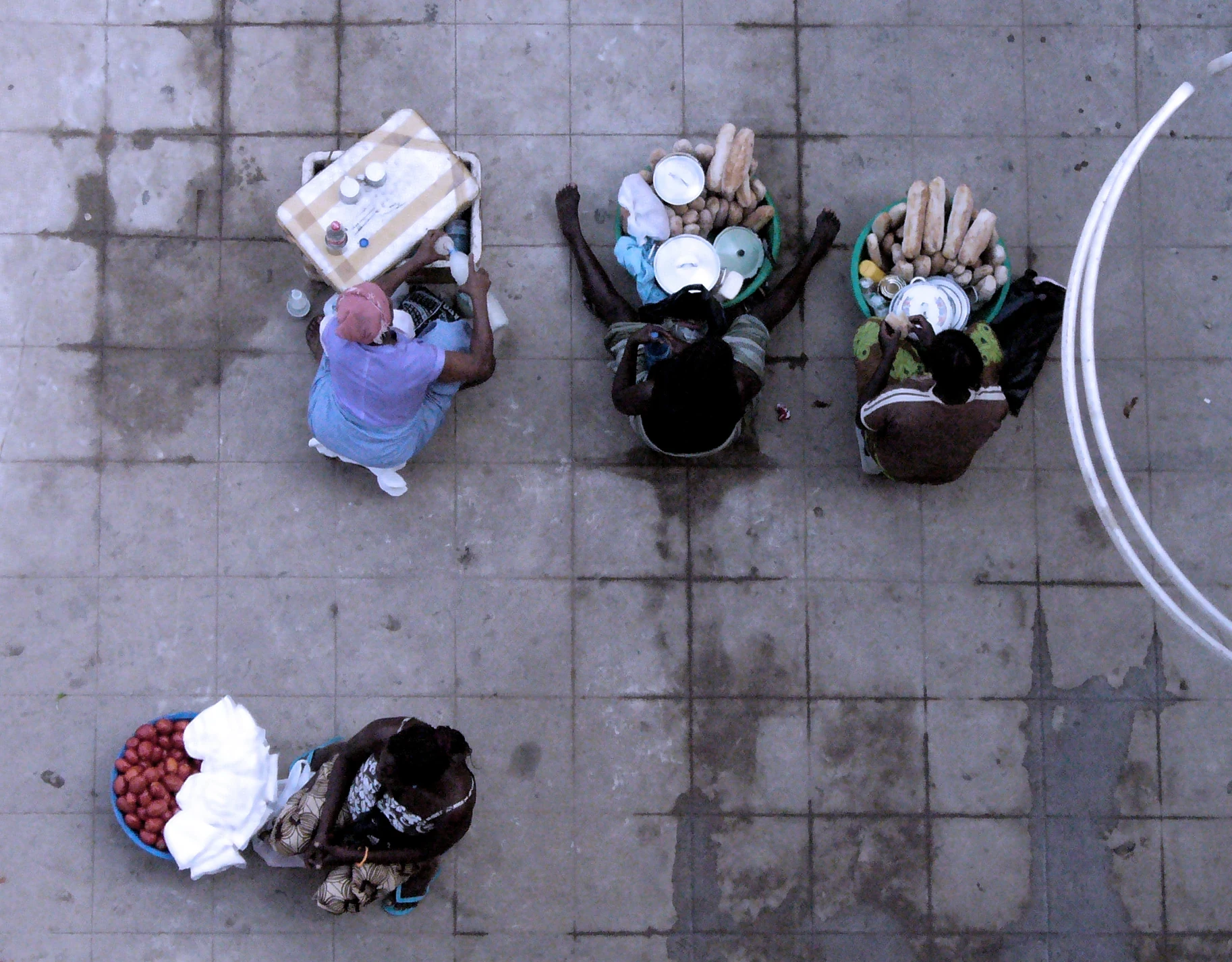 Street vendors seen from above, carrying goods on their heads
