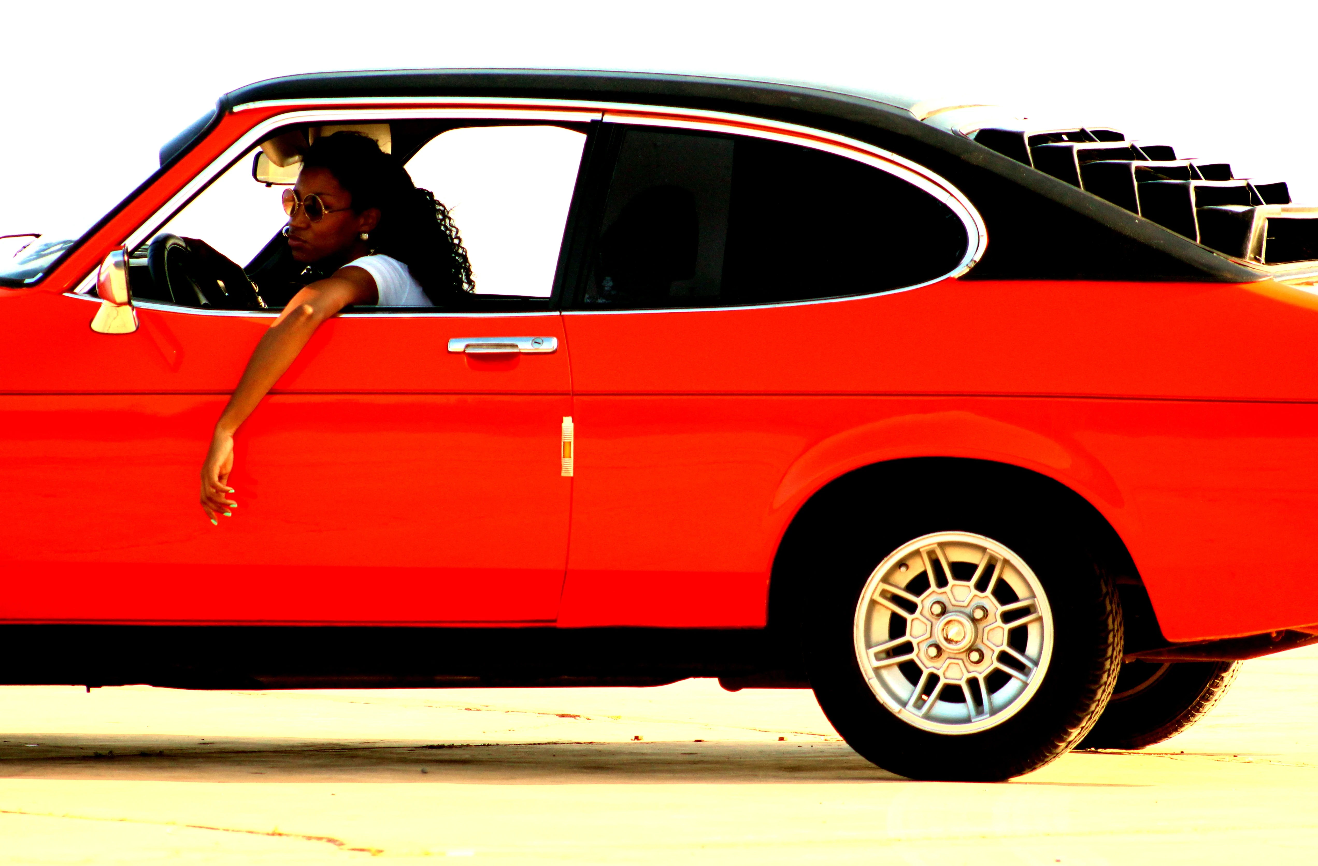 Woman leaning out of a red vintage car window